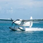 Seaplane gracefully landing on turquoise ocean waters in Key West, Florida.